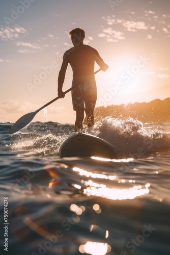 A man paddle surfing at sunset
