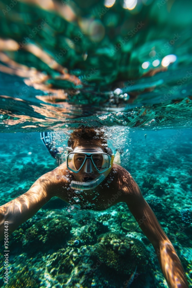 Attractive young man snorkeling in the ocean