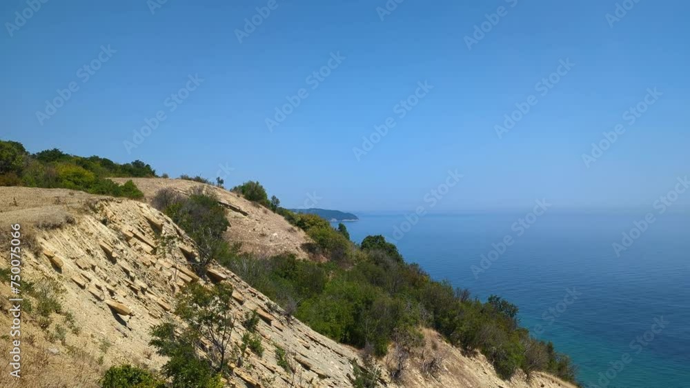 Azure sea with crystal-clear water seen from a high hill with a steep coastline on a clear sunny day. Azure sea with crystal-clear water seen from a high hill with a steep coastline on a clear sunny day.