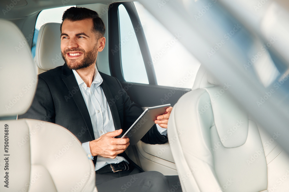 Businessman in a black suit in a car. Businessman in a black suit in a car.