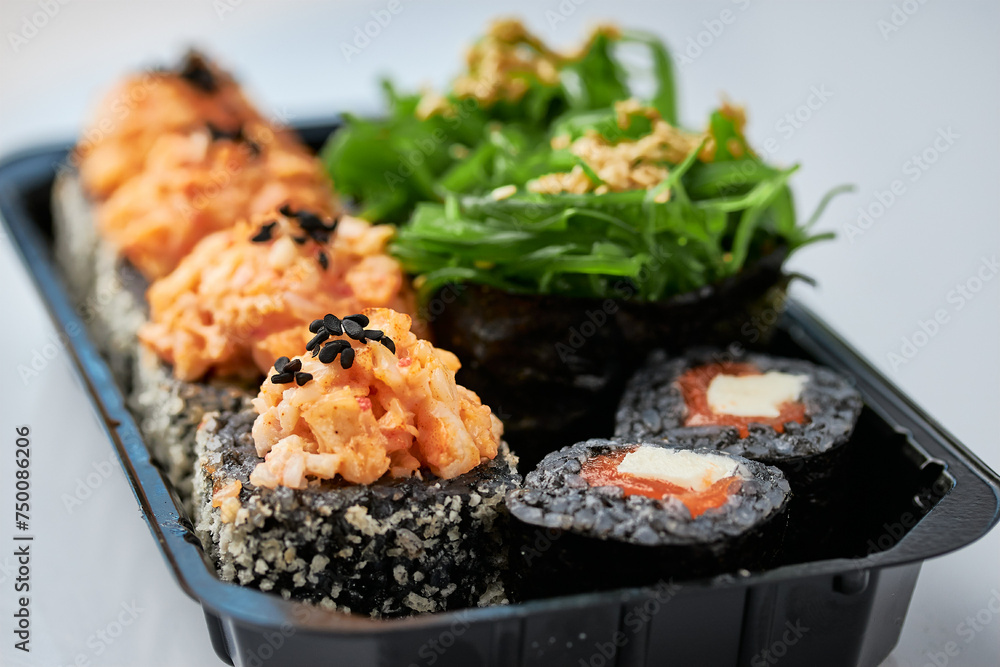 Close-up of sushi rolls made of sausage and covered with cabbage and ketchup. Homemade asian style. Sushi-food hybrids trend. Japanese food. Close-up of sushi rolls made of sausage and covered with cabbage and ketchup. Homemade asian style. Sushi-food hybrids trend. Japanese food.
