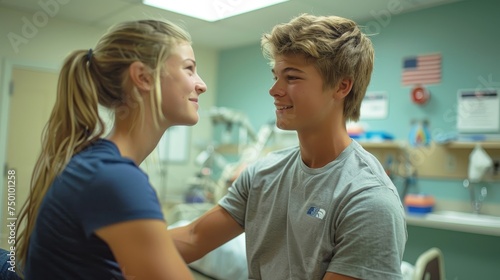 Two teenage patients share a joyful moment and smile at each other in a hospital room, suggesting friendship and support.