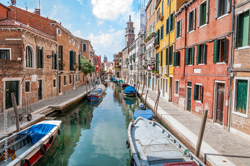 Veduta di un caratteristico canale di Venezia con barche ormeggiate e abitazioni ai lati photo