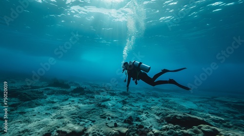 A person is diving headfirst into the clear blue water, creating ripples as they enter the surface