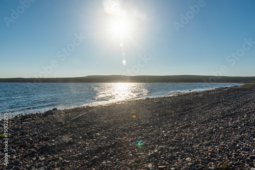 Stones and pebbles on the White Sea coast of the Kola Peninsula at sunset in summer, bright nights.
