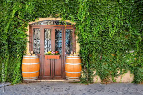 Old wine barrels outside a vine covered restaurant in Italy