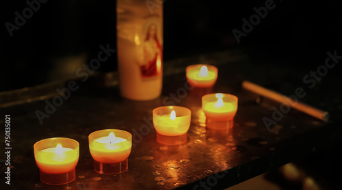 Closeup of isolated few single sacrificial candles in catholic church, blurred jesus symbol candle background - dwindling membership numbers concept