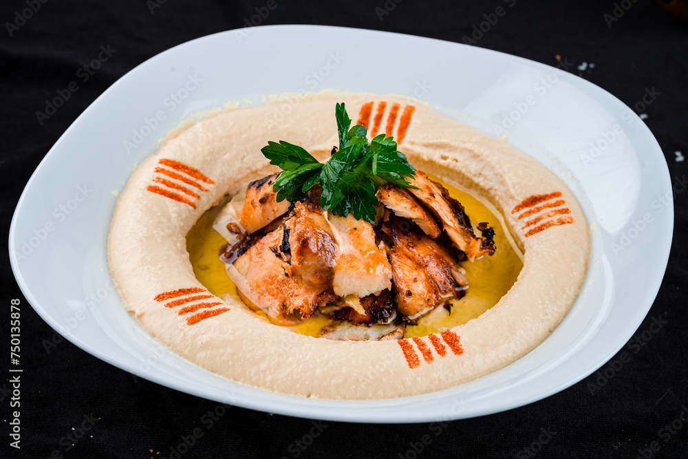 Fresh chickpea hummus with fried chicken fillet, parsley and oil. Fresh chickpea hummus with fried chicken fillet, parsley and oil.