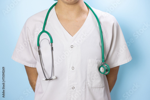 portrait of a nurse in white coat doctor with stethoscope turquoise blue background, with smiling face, making joke
