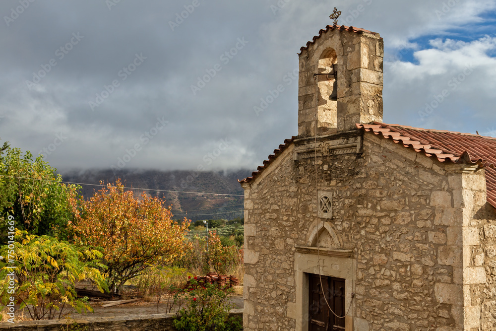 Old stone-built Greek orthodox christian church in the countryside of Crete island, Greece, during a day of November with warm light.