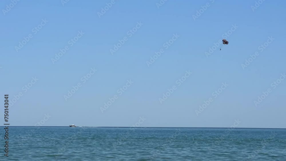 Parasailing: a boat with a marine parachute on the waves. The concept of a cloudy landscape, freedom and summer. Parachutists over the surface of the Black Sea against the sky on a summer day. 4K Parasailing: a boat with a marine parachute on the waves. The concept of a cloudy landscape, freedom and summer. Parachutists over the surface of the Black Sea against the sky on a summer day. 4K