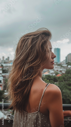 vertical portrait of a young woman with overcast cityview photo