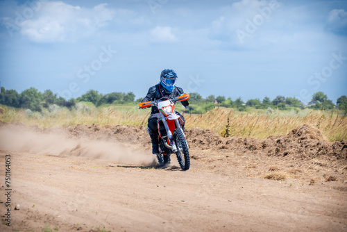 Enduro bike racer riding on dirt motocross road