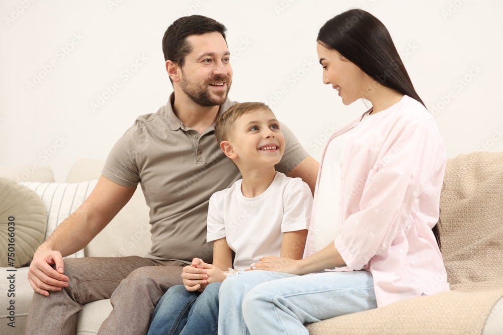 Happy pregnant woman spending time with her son and husband at home Happy pregnant woman spending time with her son and husband at home