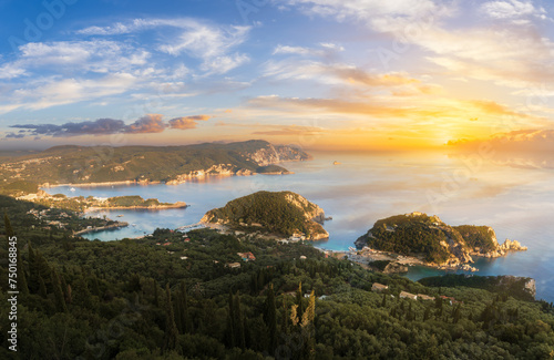 Dramatic sunset skies ignite over Paleokastritsa emerald bay, showcasing the mesmerizing natural beauty of the Greek Isles.