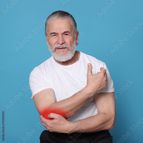 Senior man suffering from rheumatism on light blue background