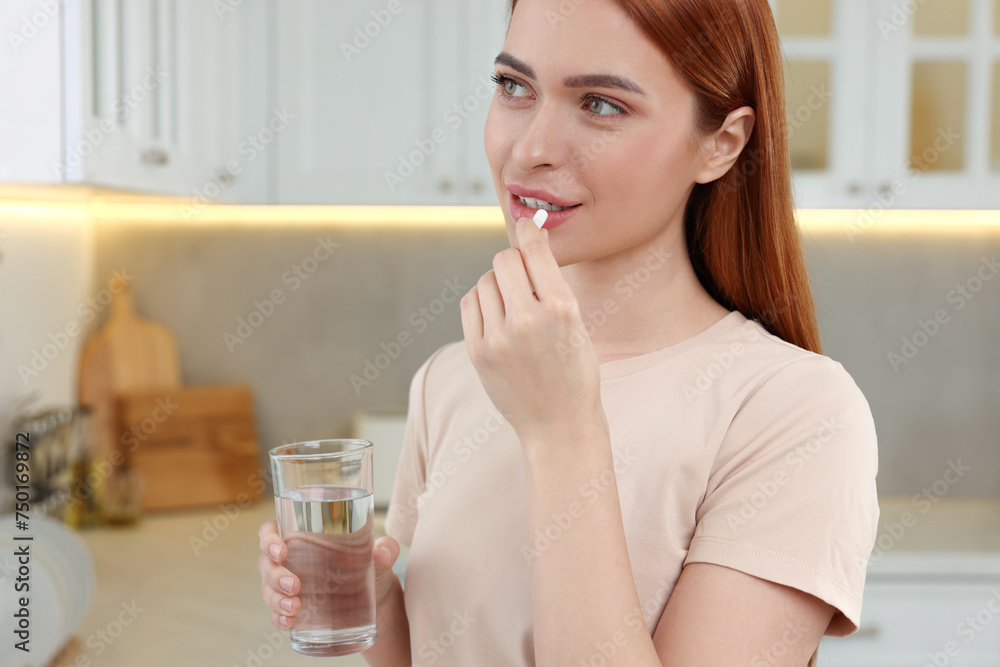 Beautiful young woman taking vitamin pill at home Beautiful young woman taking vitamin pill at home