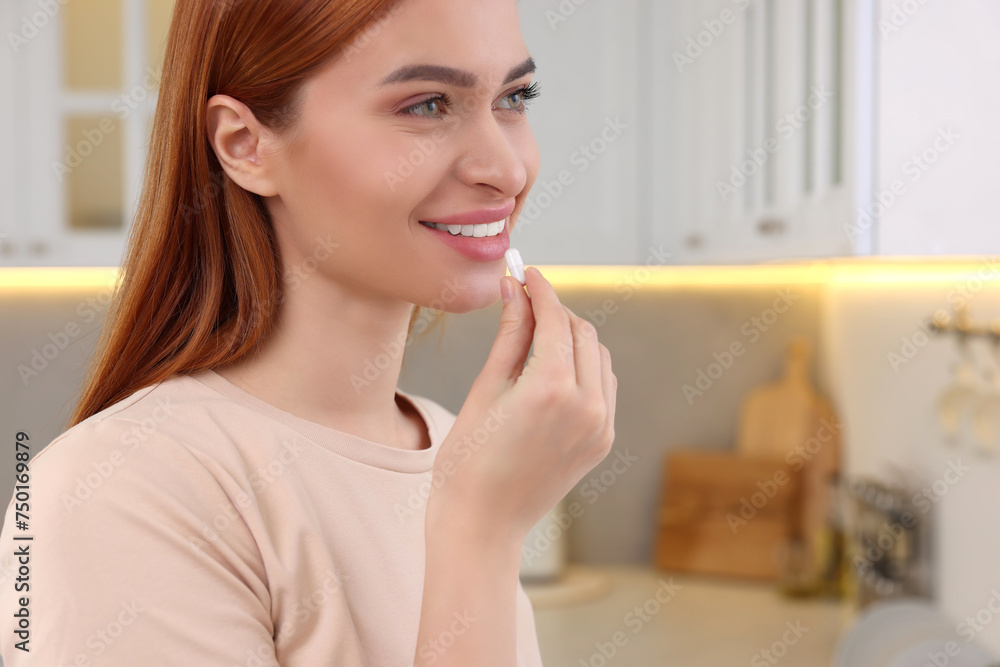 Beautiful young woman taking vitamin pill at home Beautiful young woman taking vitamin pill at home