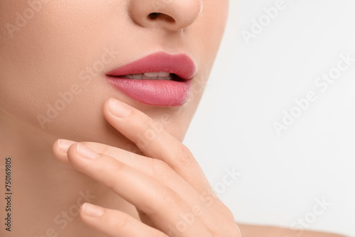 Young woman with beautiful full lips on white background  closeup