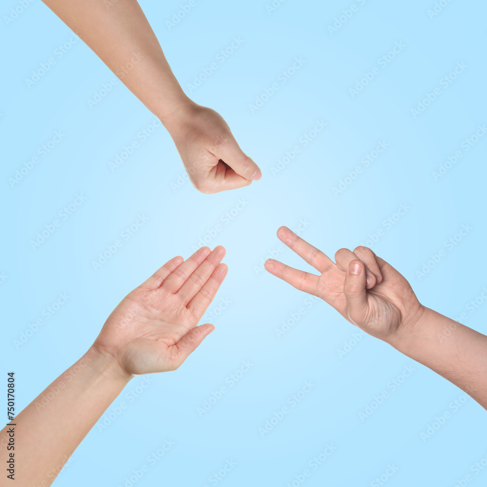 People playing rock, paper and scissors on light blue background, top view People playing rock, paper and scissors on light blue background, top view