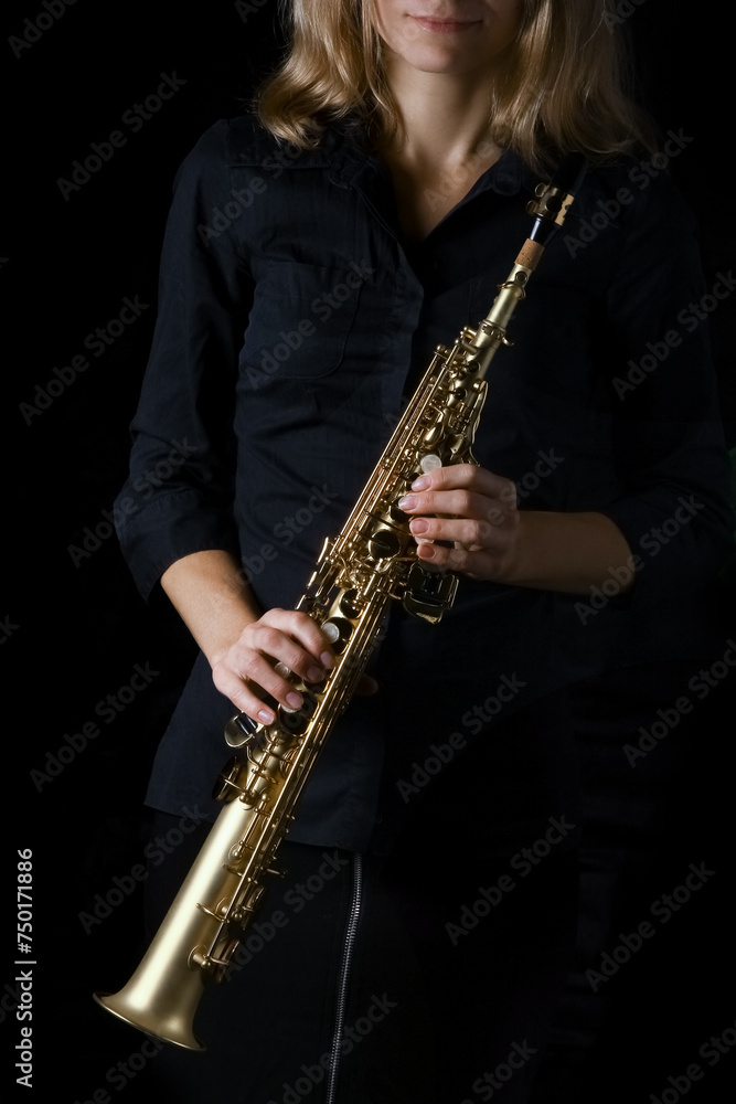 Fototapeta premium soprano saxophone in hands on a black background