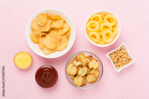 Different tasty snacks with sauce on color background, top view