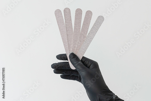 Female hand holds nails files on white background. Concept of polishing nails. Spa treatment beauty. White background with copy space.
