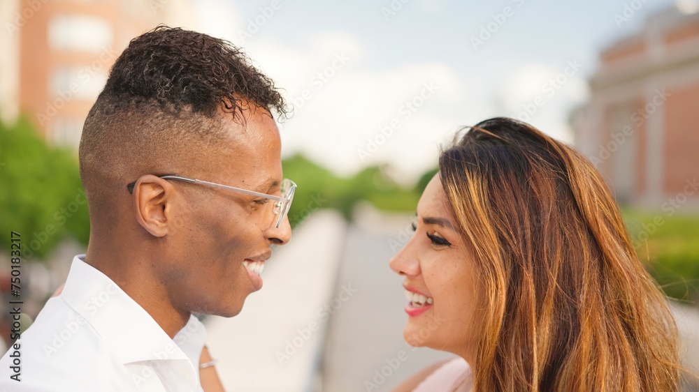 Multiethnic couple looking at each other smiling Multiethnic couple looking at each other smiling