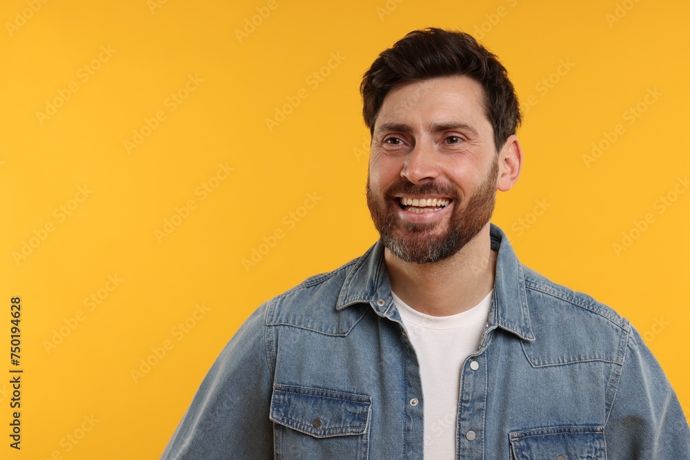 Handsome man laughing on yellow background. Space for text Handsome man laughing on yellow background. Space for text