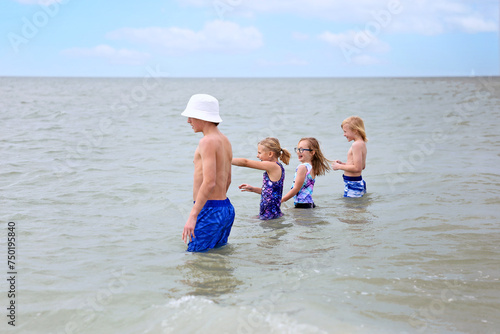 Group of Kids Playing in the Water in the Ocean on Summer Day