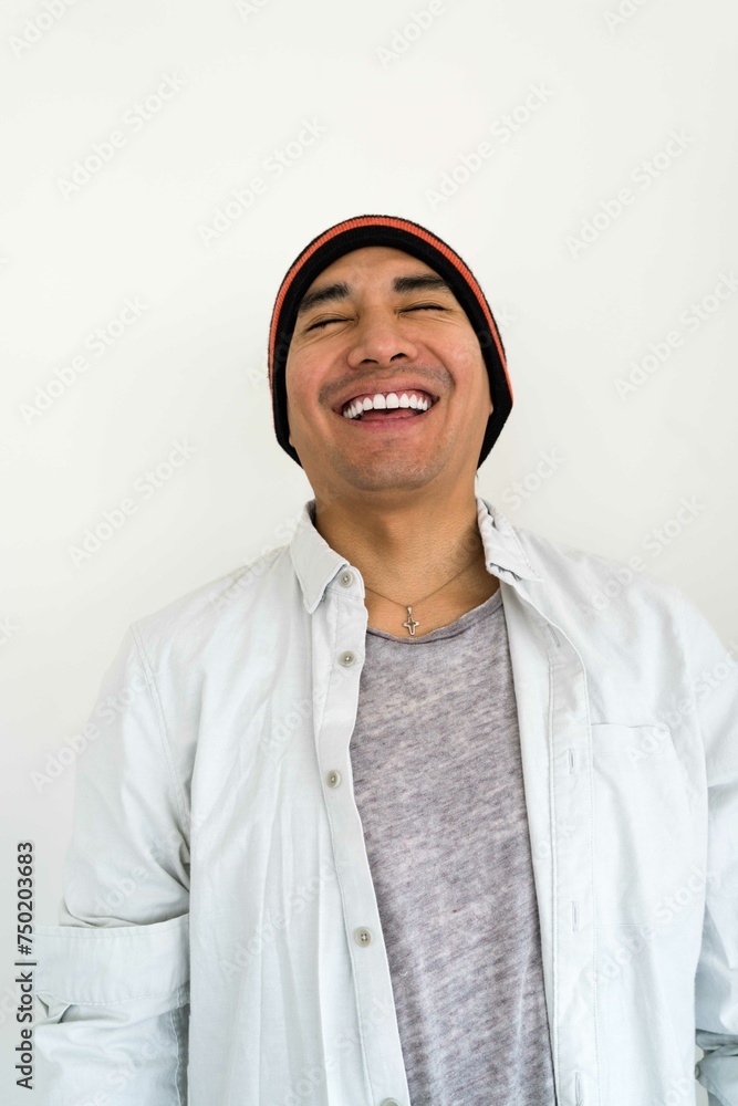 Latin man wearing a beanie on the white background smiling Latin man wearing a beanie on the white background smiling
