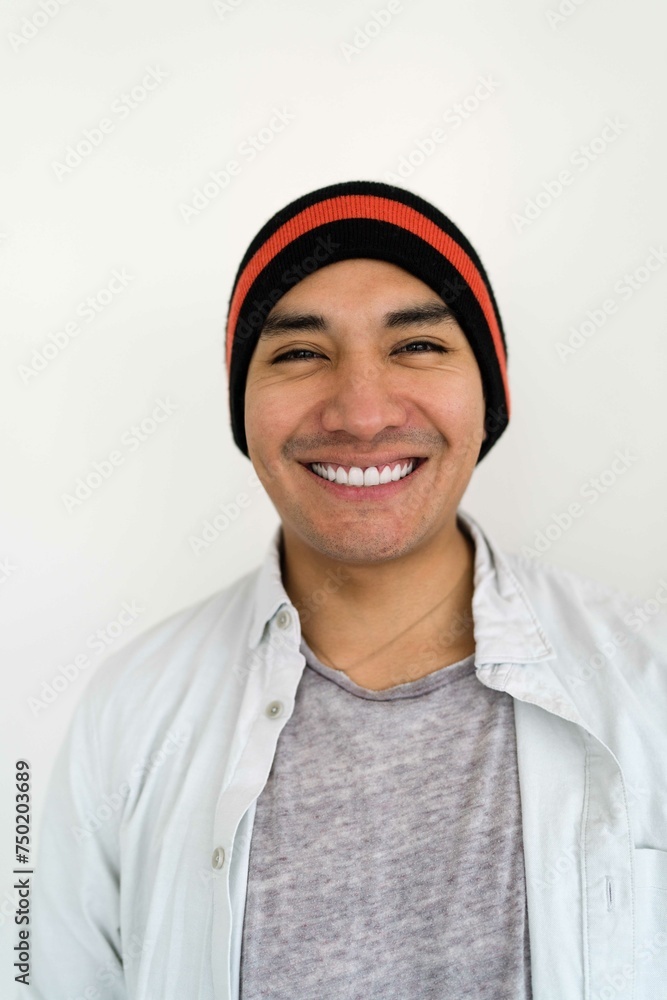 Latin man wearing a beanie on the white background smiling Latin man wearing a beanie on the white background smiling