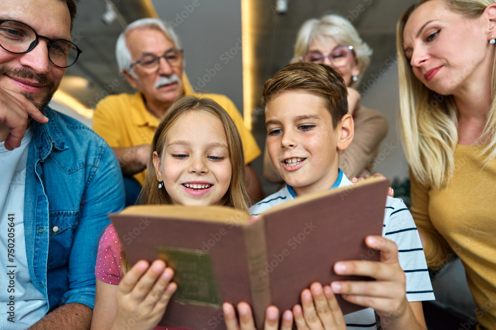 Obraz premium child family portrait woman mother man father grandmother daughter group reading book education girl grandparent generation female grandchild together senior grandfather son boy three