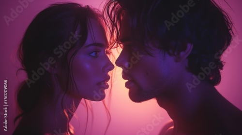  a man and a woman standing next to each other in front of a pink background with light coming from behind the man's head and the woman's head.