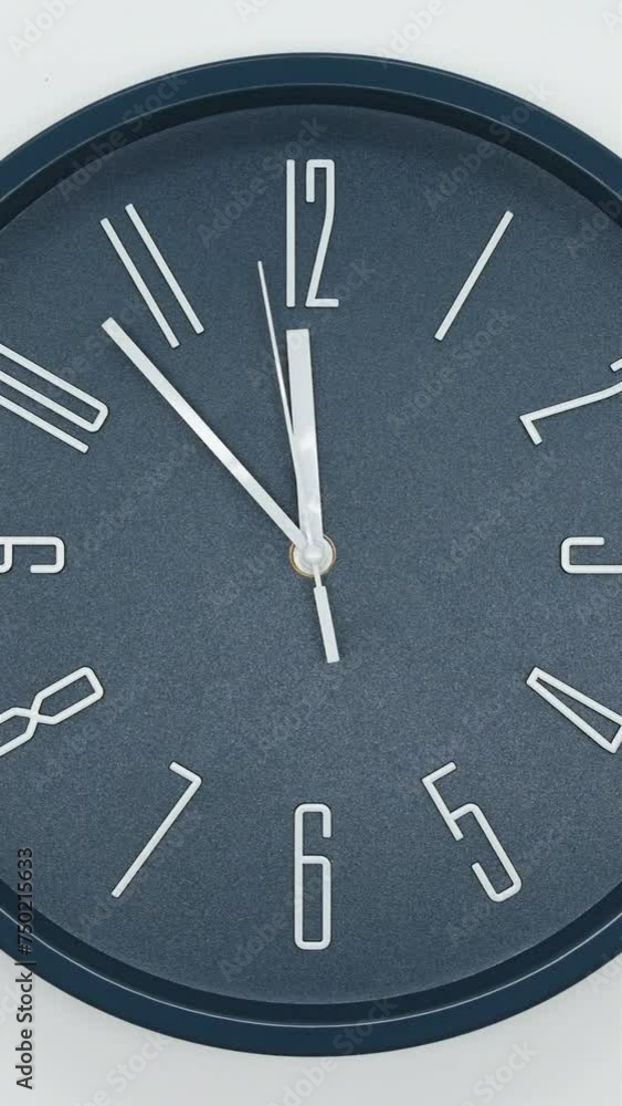 Dark Blue Wall Clock With A White Arrows And White Second Hand Of Time Of 12.00 Am Or Pm On White Background. Vertical. Timelapse. Dark Blue Wall Clock With A White Arrows And White Second Hand Of Time Of 12.00 Am Or Pm On White Background. Vertical. Timelapse.