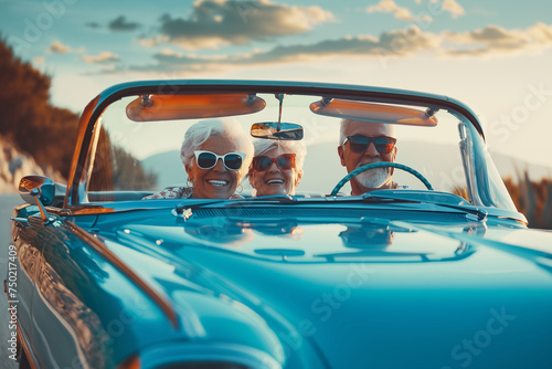 Happy mature couple and a female senior friend taking a ride in a convertible sports car.