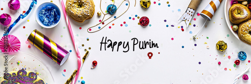 Purim celebration flat lay with noisemakers, party blowers, confetti, and donuts. photo