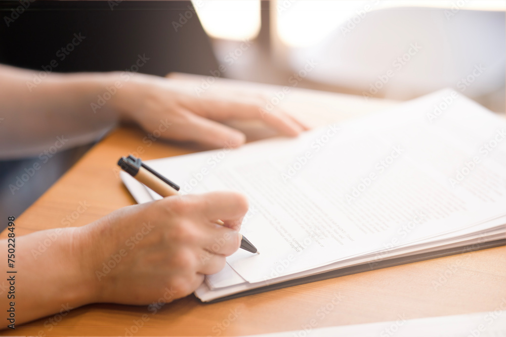 Female Cancers Sign Document With Pen, Wooden Table, Business, Loan. Woman signing important business papers at the bank or at work. Business woman working with documents, accountant, attorney Female Cancers Sign Document With Pen, Wooden Table, Business, Loan. Woman signing important business papers at the bank or at work. Business woman working with documents, accountant, attorney
