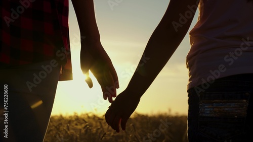 Little daughter, mom hold hands closeup, nature, sun. Parent, child outing together. Parent care for child. Family weekend. Happy family child dad. Family trust concept. Adoption of child. Silhouette