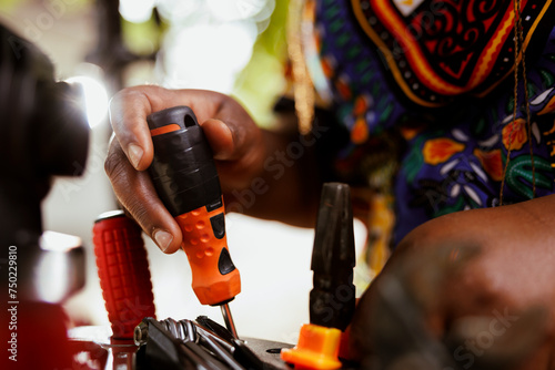Closeup shot of african american hands grasping bicycle tools from professional toolbox for maintenance and repairs. Detailed image of individual arranging specialized equipments.