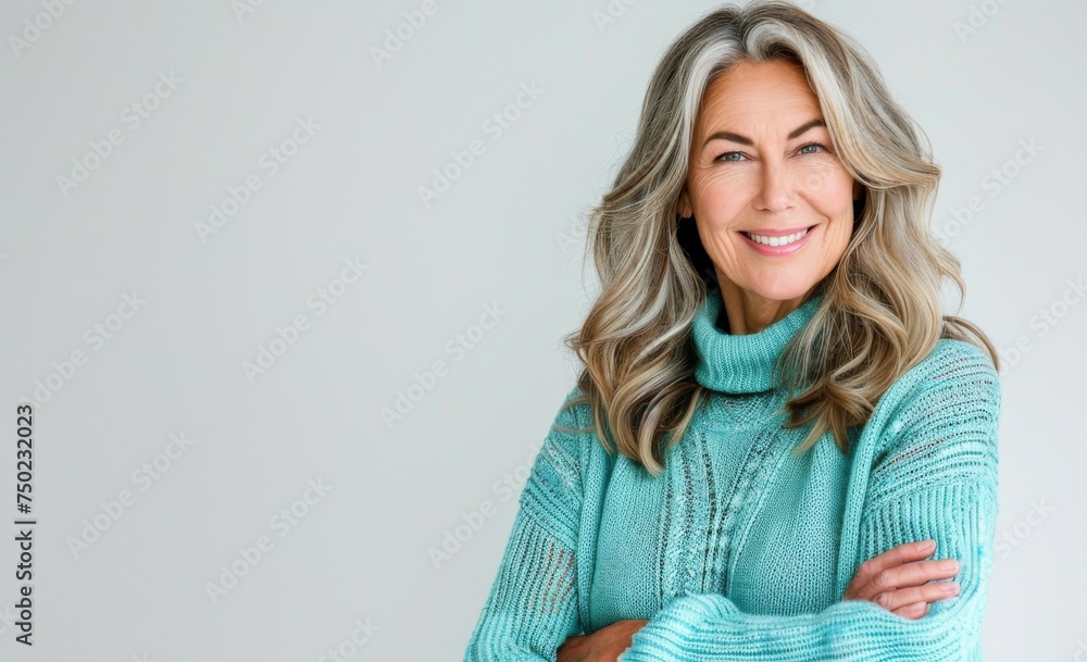 Closeup of cheerful older woman in aqua sweater arms crossed isolated on white background showing positive emotions Closeup of cheerful older woman in aqua sweater arms crossed isolated on white background showing positive emotions