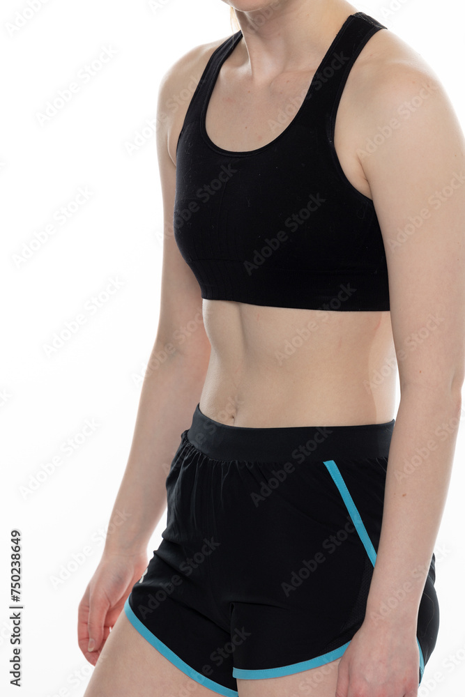 Young fit woman with an athletic stomach wearing black shorts and a black sports bra Young fit woman with an athletic stomach wearing black shorts and a black sports bra