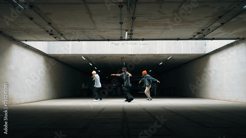 Panorama shot of hipster group dance together while perform b-boy dance. Street dancer team moving to hip hop music while doing freeze pose. Break dance, street dance. Outdoor sport 2024. Sprightly.