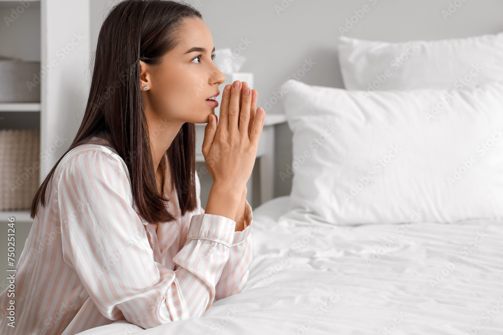 Beautiful young woman praying in bedroom at home Beautiful young woman praying in bedroom at home