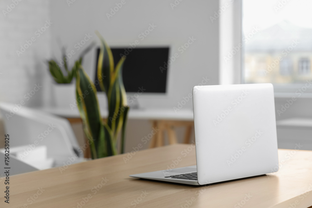 Modern laptop on desk in office, closeup Modern laptop on desk in office, closeup