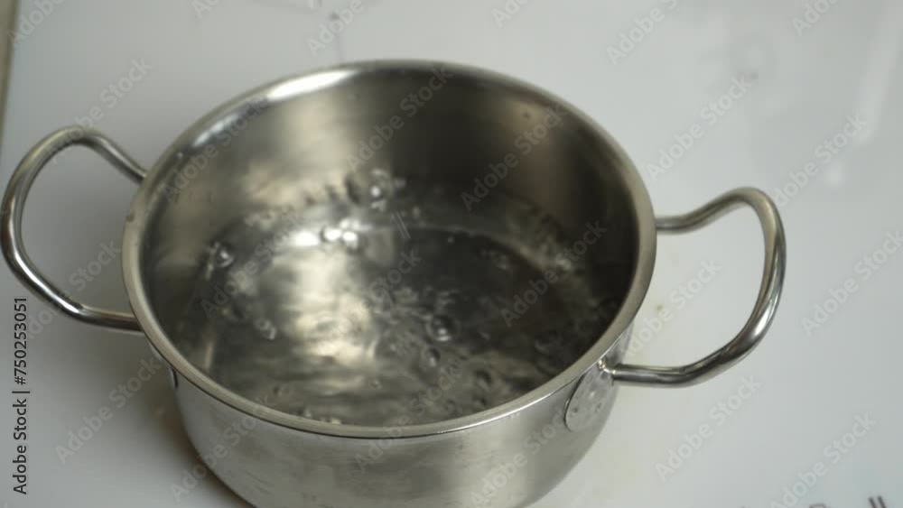 A pot fills with water on an electric stove. Captivating cooking moment, perfect for culinary content. A pot fills with water on an electric stove. Captivating cooking moment, perfect for culinary content.