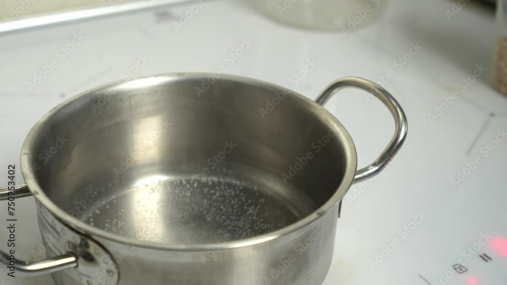 A pot fills with water on an electric stove. Captivating cooking moment, perfect for culinary content. A pot fills with water on an electric stove. Captivating cooking moment, perfect for culinary content.