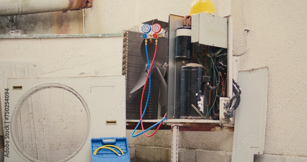 Revealing handheld camera shot of broken outdoor air cooling unit