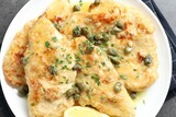 Delicious chicken piccata with herbs on grey table, top view