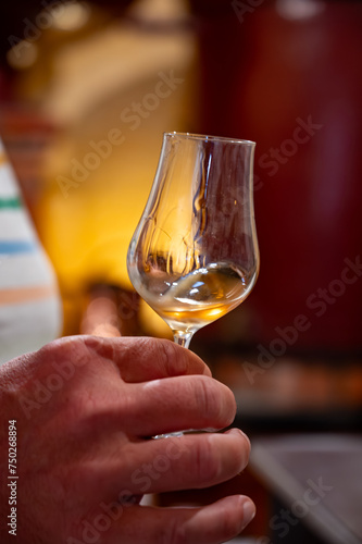 Tasting of cognac spirit aged in old French oak barrels in cellar in distillery in Cognac white wine region, Charente, Segonzac, Grand Champagne, France